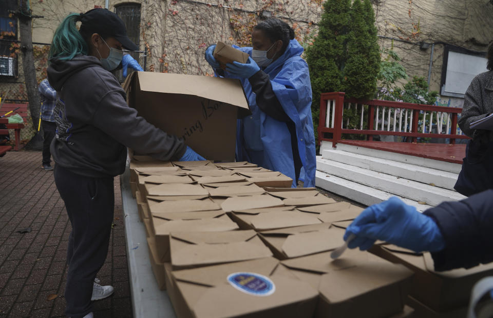 Volunteers unload boxed meals prepared at the South Bronx restaurant La Morada, Wednesday Oct. 28, 2020, in New York. After a fund raising campaign during the coronavirus pandemic, La Morada, an award winning Mexican restaurant, was reopened and now also functions as a soup kitchen, serving 650 meals daily. (AP Photo/Bebeto Matthews)