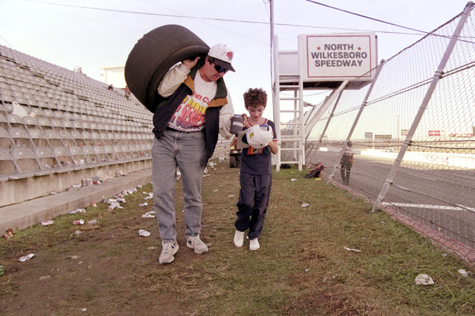 A fan leaves the North Wilkesboro Speedway on Sept. 29, 1996, in North Wilkesboro, N.C., with a souvenir tire after Jeff Gordon won the last NASCAR cup race run at the track before it closed. The track has reopened and will host the NASCAR All-Star auto race this weekend. (AP Photo/Bob Jordan, File)