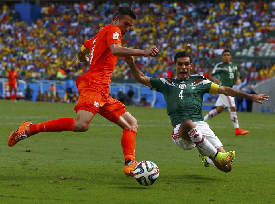Robin van Persie of the Netherlands fights for the ball against Mexico's Rafael Marquez during their 2014 World Cup round of 16 game at the Castelao arena in Fortaleza