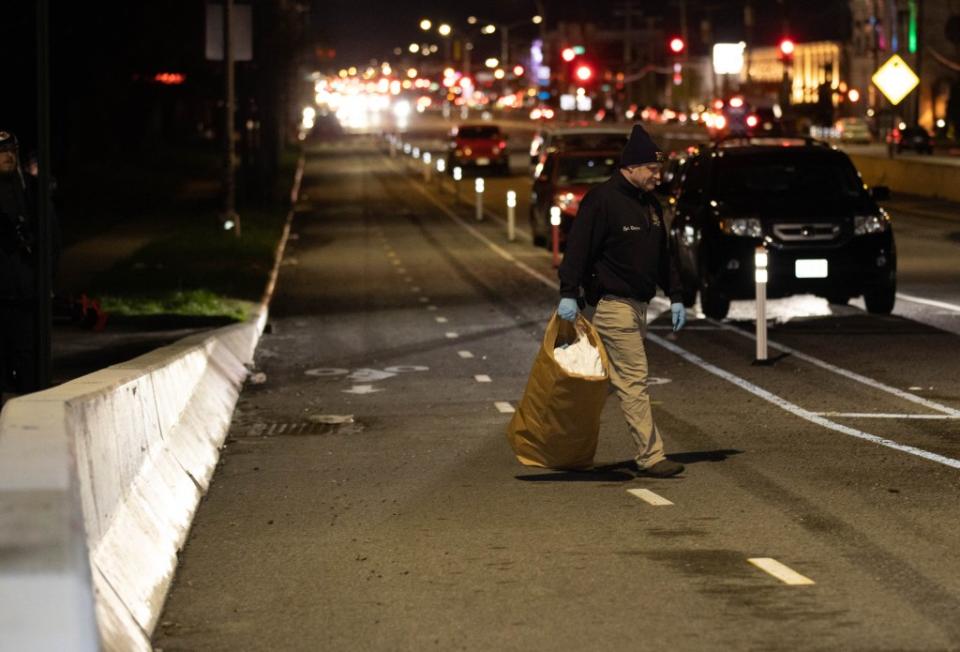 Crime Scene Unit officers carry bags of evidence from the Cross Bay Bridge where a body was found on Friday, April 12, 2024. Robert Mecea