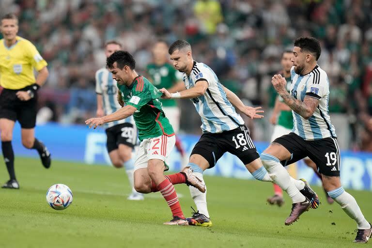 El volante argentino Guido Rodríguez (centro) sujeta la casaca del atacante mexicano Hirving Lozano en el partido por el Grupo C del Mundial, el sábado 26 de noviembre de 2022, en Lusail, Qatar. (AP Foto/Moisés Castillo)