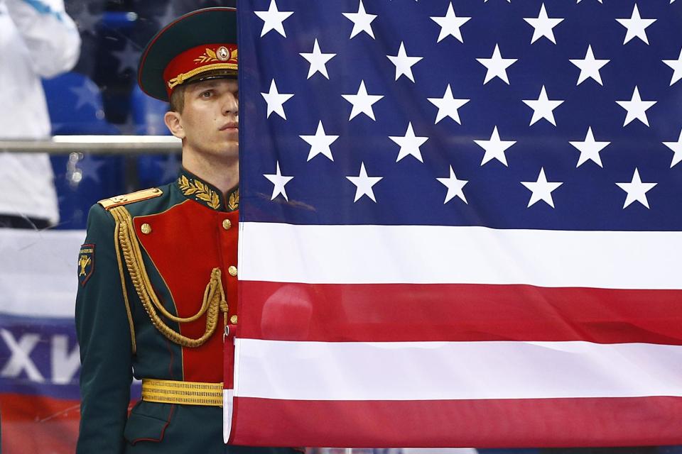 A Russian honor guard soldier stands behind the United States flag after the gold medal ice sledge hockey match between United States and Russia at the 2014 Winter Paralympics in Sochi, Russia, Saturday, March 15, 2014. United States won 1-0. (AP Photo/Pavel Golovkin)