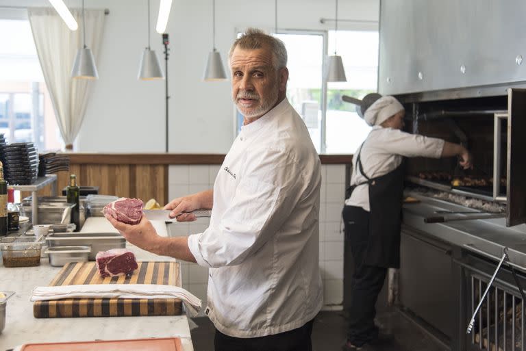 Christian Petersen corta un bife antes de tirarlo a la plancha