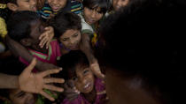 In this Wednesday, Jan. 17, 2018, file photo, Rohingya refugee children push each other to receive a packet of Khichdi, made from rice and lentils, at a food distribution centre in Balukhali refugee camp near Cox's Bazar, Bangladesh. United Nations agencies are warning that more than 350 million people in the Asia-Pacific are going hungry as the coronavirus pandemic destroys jobs and pushes food prices higher. (AP Photo/Manish Swarup, File)