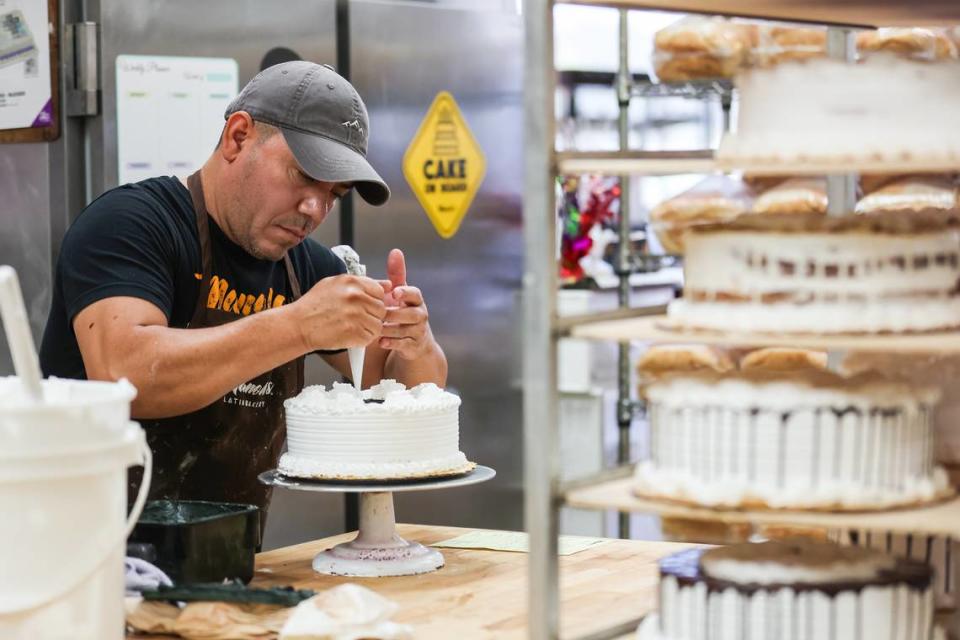 Victor Zelaya, a baker, or ‘pastelero’, at Manolo’s Bakery decorates a special order cake for a sixteenth birthday on Tuesday, June 17, 2022 in Charlotte, NC. 