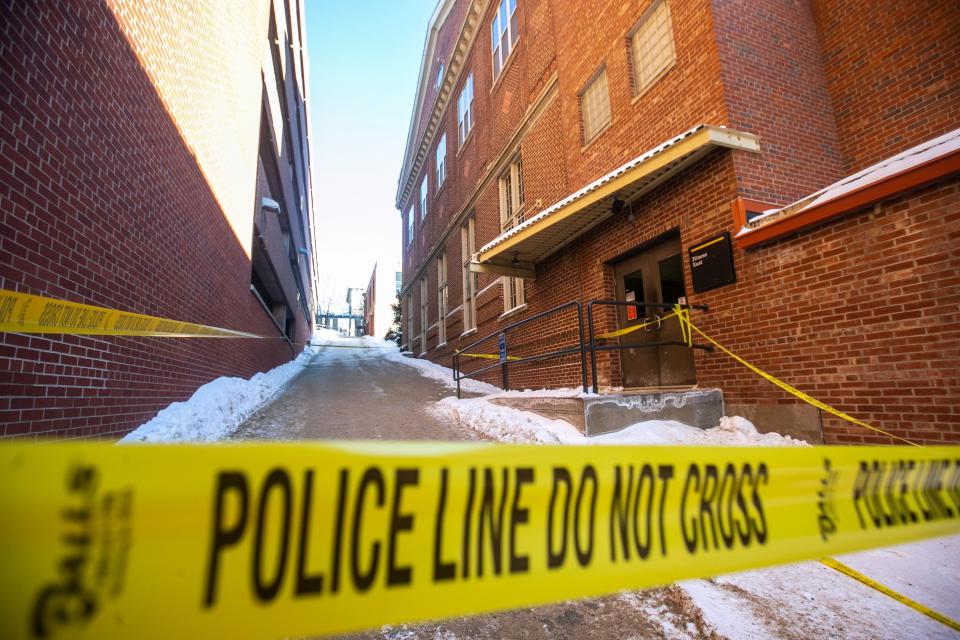 Yellow police tape blocks off a crime scene.