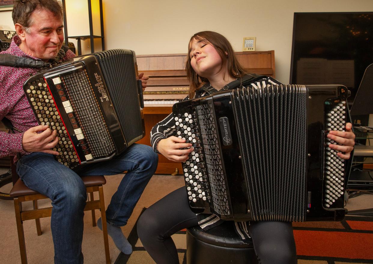 Maria Telesheva, right, plays the accordion with her father Sergei Telesheva at their Eugene home on Dec. 13, 2023.