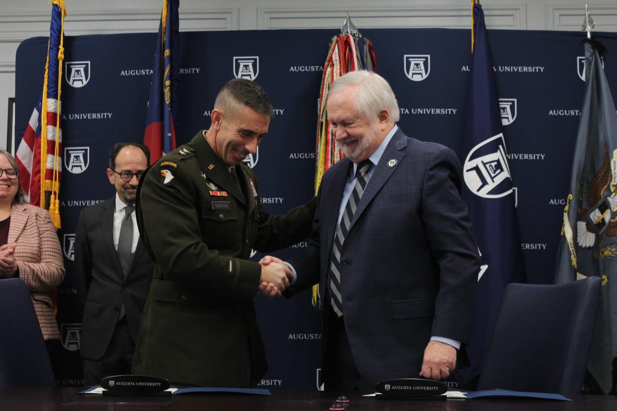 Maj. Gen. Paul T. Stanton, left, shakes hands with Augusta University President Brooks Keel. The two men signed a memorandum of understanding allowing soldiers to receive course credit in the university's new online graduate degrees for military coursework on Thursday, Jan. 19