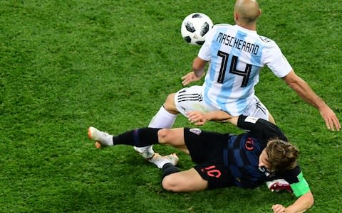 Modric gets stuck in to Mascherano - Credit: MARTIN BERNETTI/AFP/Getty Images