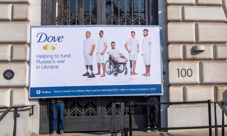 <span>Members of the Ukraine Solidarity Project with a protest billboard in the style of a Dove advert outside the Unilever HQ in London in 2023.</span><span>Photograph: Jill Mead/The Guardian</span>