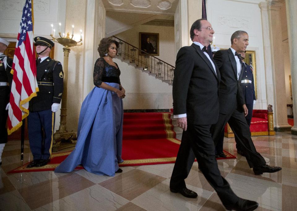 First Lady Michelle Obama, left, follows her husband President Barack Obama and French President Francois Hollande, center, after posing at the Grand Staircase, Tuesday, Feb. 11, 2014, for a State Dinner at the White House in Washington. (AP Photo/Pablo Martinez Monsivais)