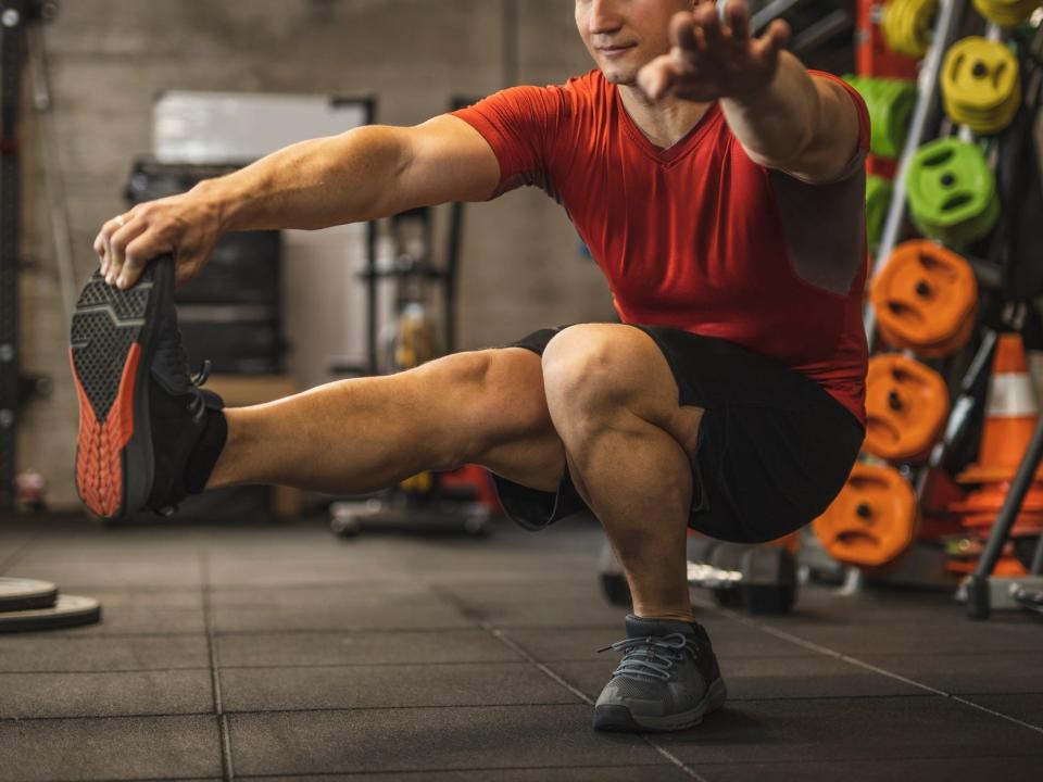 an athlete performing single leg squat exercises, or pistol squats, in a gym