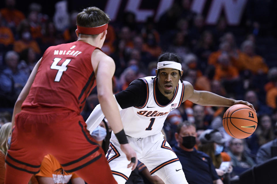 Illinois' Trent Frazier (1) dribbles as Rutgers' Paul Mulcahy defends during the first half of an NCAA college basketball game Friday, Dec. 3, 2021, in Champaign, Ill. (AP Photo/Michael Allio)