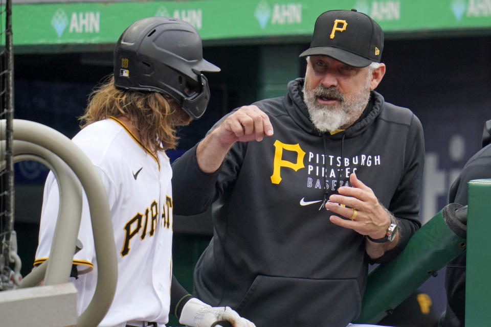 Pittsburgh Pirates manager Derek Shelton, right, talks with Ben Gamel on the dugout steps during the second inning of a baseball game against the Cincinnati Reds in Pittsburgh, Sunday, Oct. 3, 2021. (AP Photo/Gene J. Puskar)