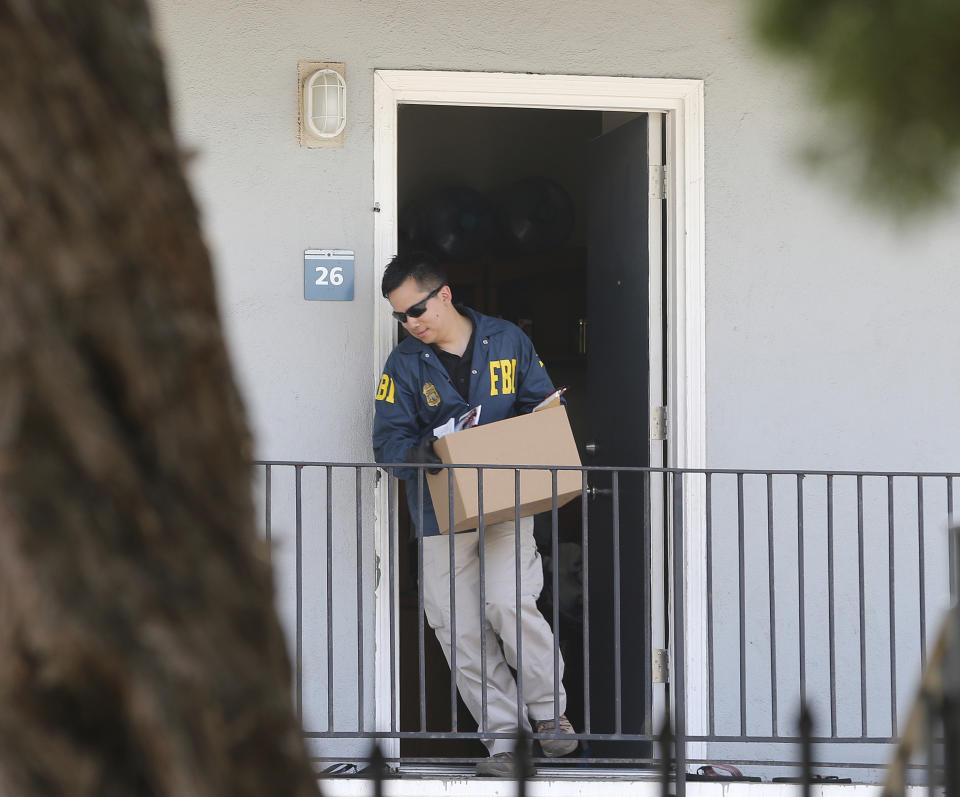 A federal agent removes items from an apartment following the arrest of Omar Ameen, Wednesday, Aug. 15, 2018, in Sacramento, Calif. Ameen, a 45-year-old Iraqi refugee, was arrested on a warrant alleging that he killed an Iraqi policeman in 2014 while serving with the Islamic State terror organization. (AP Photo/Rich Pedroncelli)