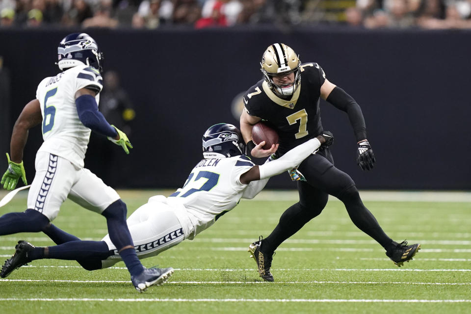 New Orleans Saints' Taysom Hill (7) carries the ball as Seattle Seahawks cornerback Tre Brown tries to make the tackle during an NFL football game in New Orleans, Sunday, Oct. 9, 2022. (AP Photo/Gerald Herbert)