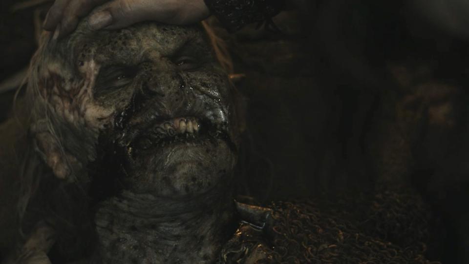 A dying orc smiles at Adar as he holds the orcs head on The rIngs of Power