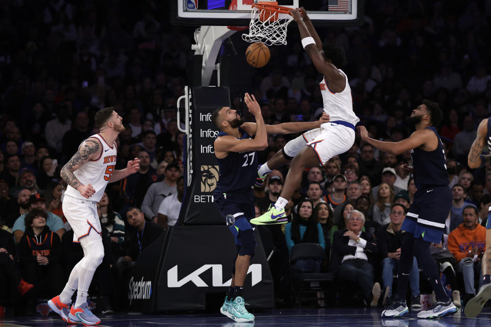 New York Knicks forward OG Anunoby dunks the ball over Minnesota Timberwolves center Rudy Gobert (27) during the first half of an NBA basketball game, Monday, Jan. 1, 2024, in New York. (AP Photo/Adam Hunger)