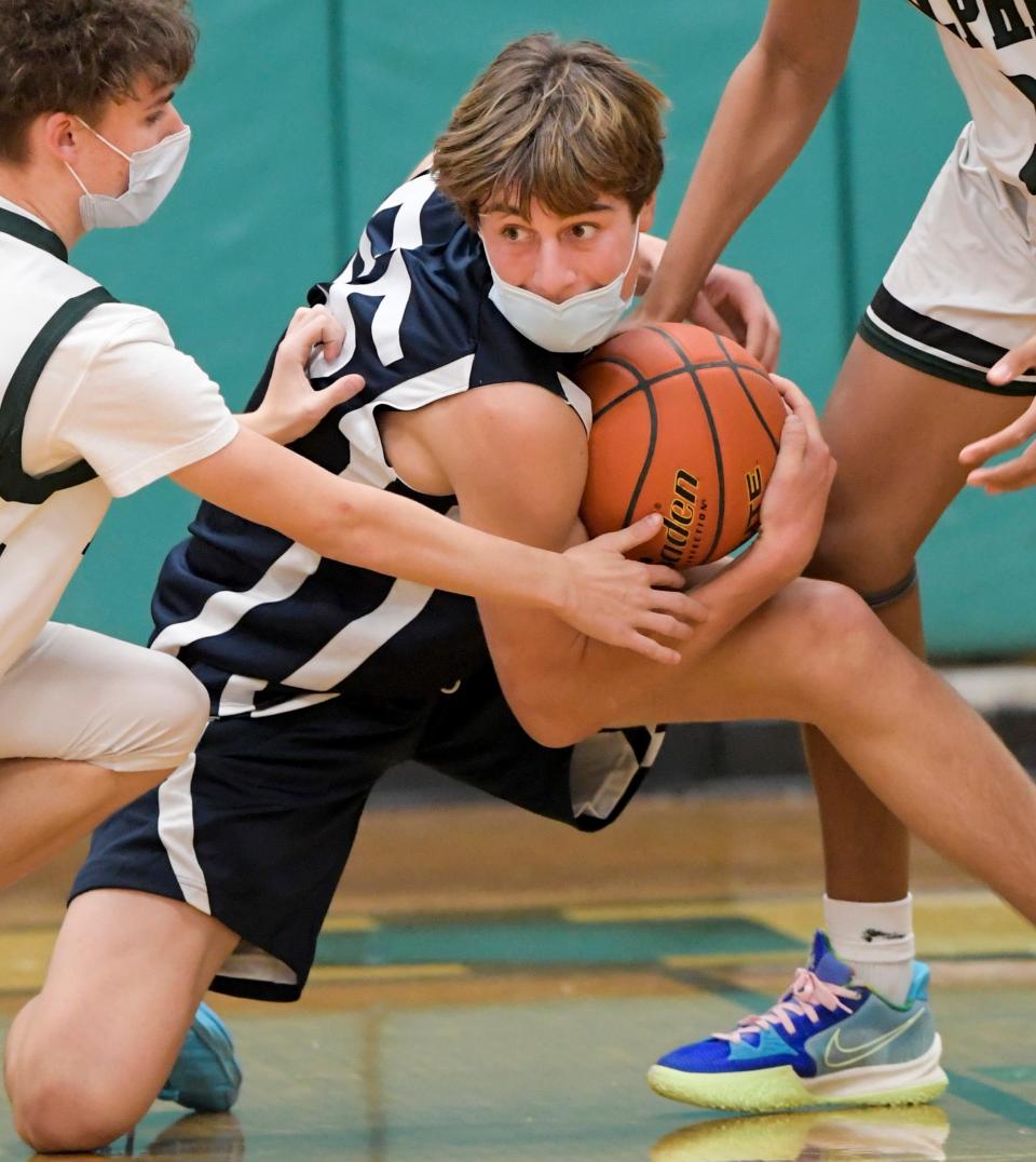 In this game from January 2022, Jack Halik of Nantucket attempts to avoid the tie up between Darius Azor and Connor Bosiak of Dennis-Yarmouth.