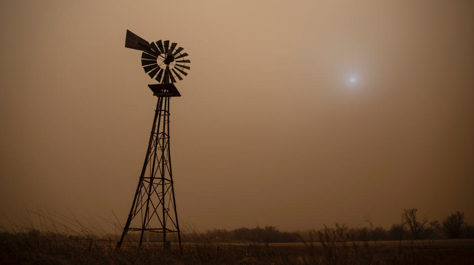 The dust from heavy winds obscures the sun in Hodgeman County in Jetmore, Kans., Wednesday, Dec. 15, 2021. (Travis Heying/The Wichita Eagle via AP)