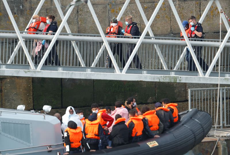 Migrants disembark after arriving at Dover harbour, in Dover