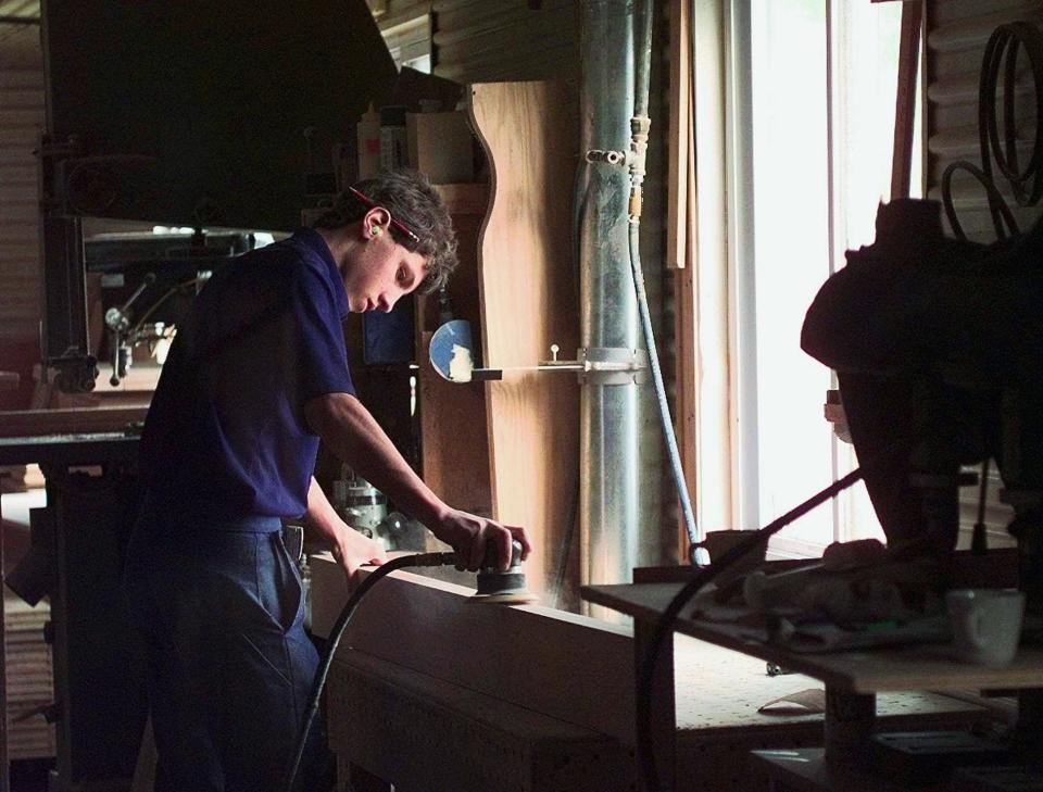 Amish 16-year-old Abe Yoder sands a piece of a bed frame at an Amish furniture manufacturer in Applecreek, Ohio, Friday, Oct. 3, 1997.