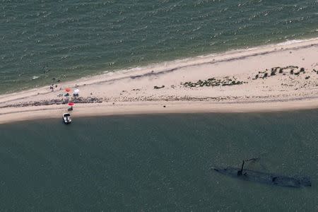 Visitors swim in the waters along a sandbar on the south side of Tangier Island, Virginia, U.S., August 3, 2017. REUTERS/Adrees Latif