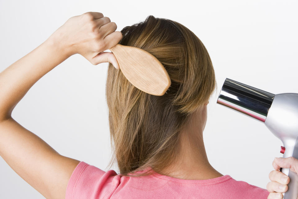 Woman brushing and drying hair