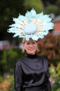 A racegoer wears a giant, floral hat with a black satin outfit. <em>[Photo: Getty]</em>