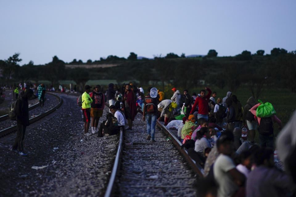 Migrants wait along rail lines hoping to board a freight train heading north, one that stops long enough so they can hop on, in Huehuetoca, Mexico, Sept. 19, 2023. Ferromex, Mexico's largest railroad company announced that it was suspending operations of its cargo trains due to the massive number of migrants that are illegally hitching a ride on its trains moving north towards the U.S. border. (AP Photo/Eduardo Verdugo)