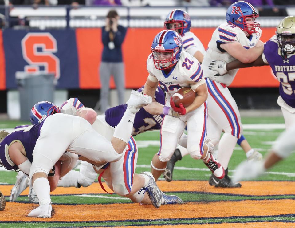 Carmel's Tristan Werlau (22) looks for some running room in the Christian Brothers Academy defense during the New York State Class AA championship at the JMA Dome in Syracuse Dec. 3, 2023.