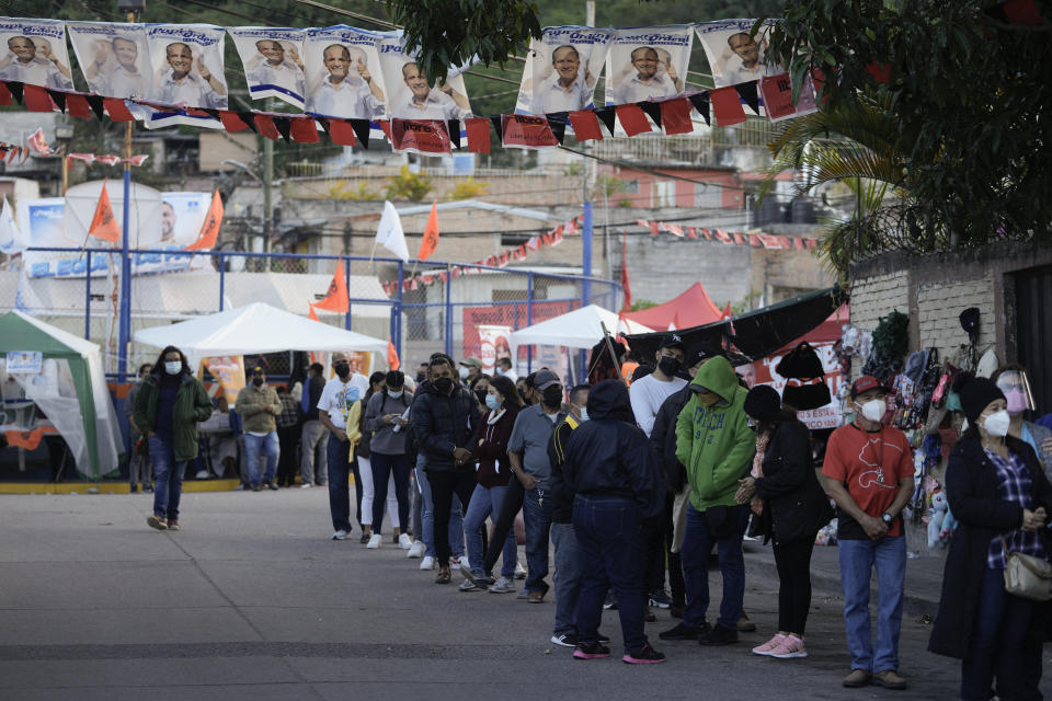 Voters line up outside a polling station during general elections in Tegucigalpa, Honduras, Sunday, Nov. 28, 2021. (AP Photo/Moises Castillo)