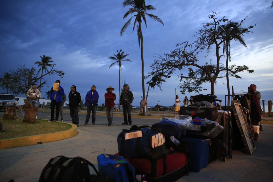 Prison employees who are being transferred to jails in other parts of Mexico wait to have their belongings inspected by security dogs before boarding a Naval ship, during a media tour of the now closed Islas Marias penal colony located off Mexico's Pacific coast, at dawn Sunday, March 17, 2019. Some of prison employees want to stay on and are trying to get transfers to the Environment Department, which will now oversee the islands. (AP Photo/Rebecca Blackwell)