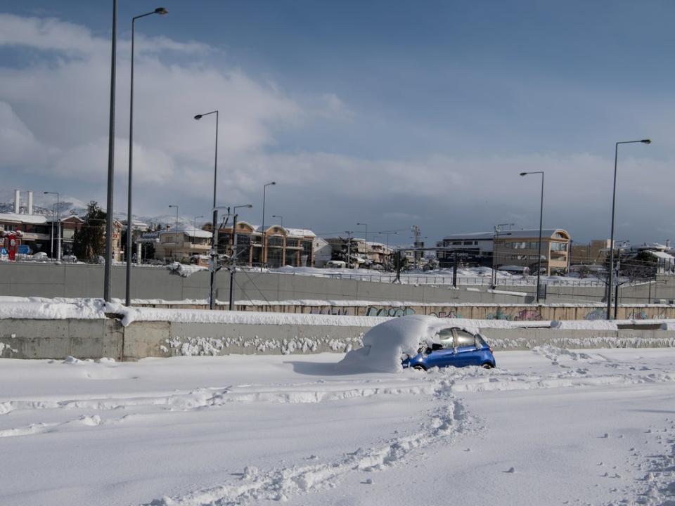 An abandoned vehicle is seen in an motorway way after a snowstorm in Athens on 24 January 2022 (AP)