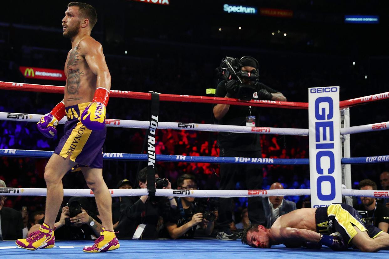 Anthony Crolla face down on the canvas as Vasily Lomachenko walks back to his corner