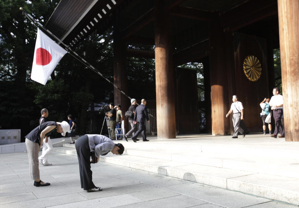 FILE - In this Aug. 15, 2013 file photo, worshippers bow at Yasukuni Shrine in Tokyo. Justin Bieber has apologized to those he offended by visiting Japan's Yasukuni war shrine the week of April 20, 2014, saying he was misled to see it as only a place of prayer. The Shinto shrine in Tokyo honors 2.5 million war dead, including 14 convicted war criminals. China and South Korea in particular see Yasukuni as a symbol of Japan's past militarism and see visits to it as a lack of understanding or remorse over wartime history. (AP Photo/Shizuo Kambayashi, File)