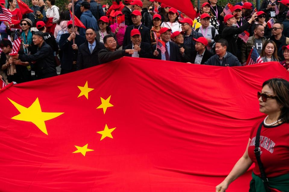 John Chan and other pro-China demonstrators unfurl a massive People’s Republic of China flag to welcome Chinese leader Xi Jinping to the APEC summit in San Francisco. Jungho Kim