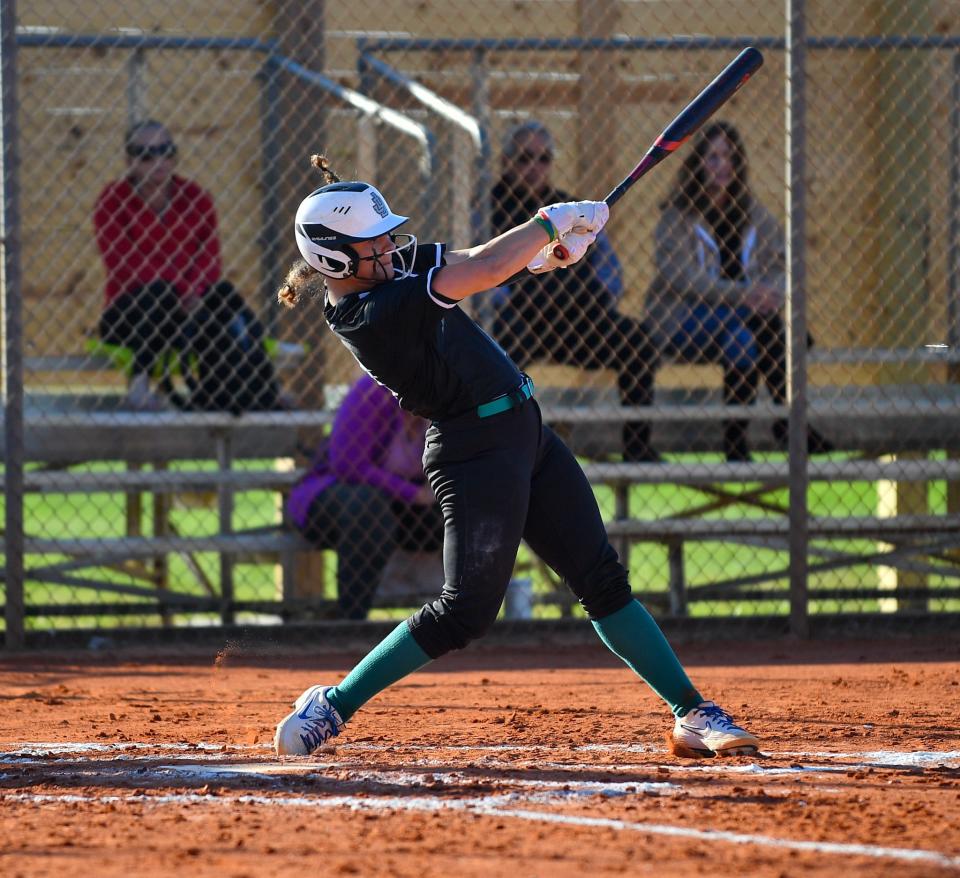Jensen Beach’s Molly Santiago (21) takes a swing in a high school softball game against Centennial, Wednesday, Feb. 21, 2024, in Port Saint Lucie.