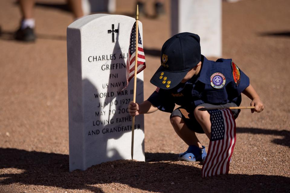 Cub Scouts troops place flags on the graves at Fort Bliss Cemetery before Memorial Day on Saturday, May 25, 2024.