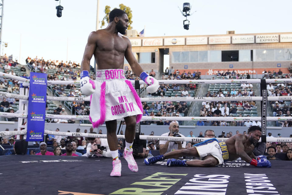Jaron Ennis, left, looks back after knocking out Custio Clayton, right, during a welterweight boxing bout Saturday, May 14, 2022, in Carson, Calif. (AP Photo/Marcio Jose Sanchez)