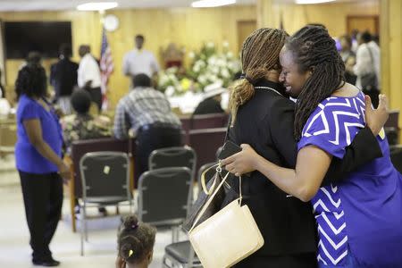 Waltrina Middleton (R), cousin of shooting victim DePayne Doctor, embraces Claudia Lawton in the basement where a mass shooting occurred at the Emanuel A.M.E. Church four days ago, in Charleston, South Carolina in this June 21, 2015, file photo. REUTERS/David Goldman/Pool