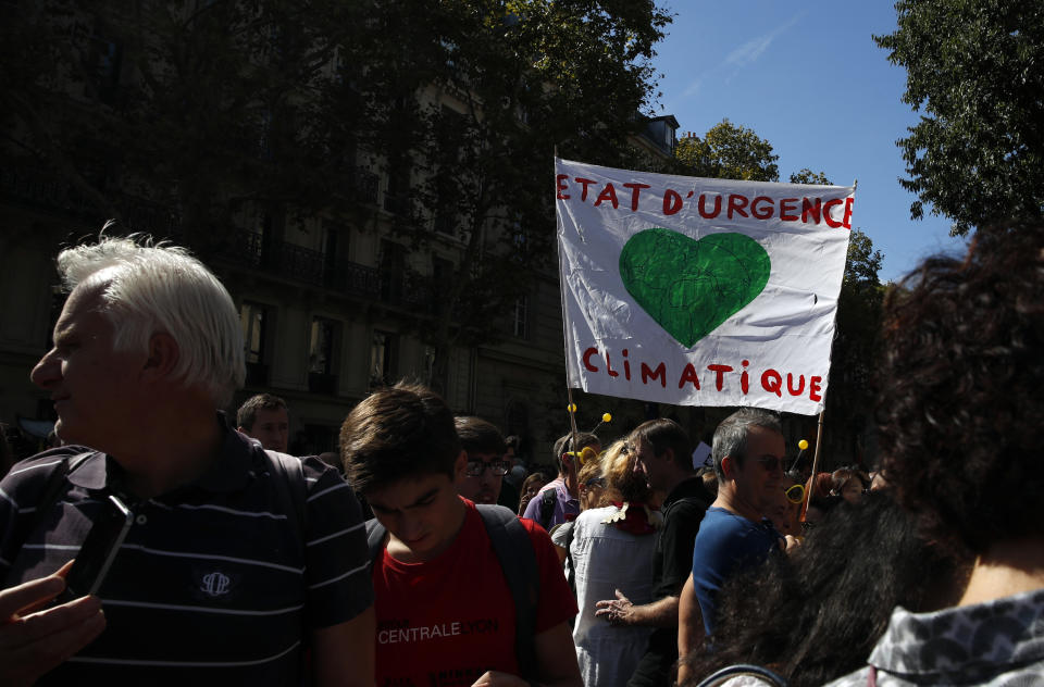 A man holds a poster reading: State of emergency for climate, during a protest in Paris, Saturday, Sept. 8, 2018. Demonstrators in cities across France and Europe were marching on Saturday as part of a global day of protest ahead of a climate action summit this month in San Francisco, California. (AP Photo/Christophe Ena)