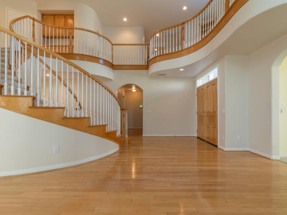 An empty entryway with curved stairs.