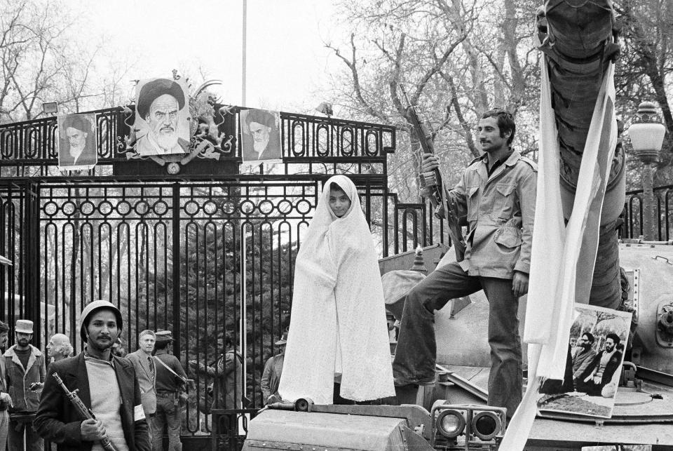 FILE - In this undated photo from 1979, a small Iranian girl stands on a captured tank at the entrance to Niavaran Palace where Shah Mohammad Reza Pahlavi once lived in Tehran, Iran. Forty years ago, Iran's ruling shah left his nation for the last time and an Islamic Revolution overthrew the vestiges of his caretaker government. The effects of the 1979 revolution, including the takeover of the U.S. Embassy in Tehran and ensuing hostage crisis, reverberate through decades of tense relations between Iran and America. (AP Photo/Aristotle Saris, File)