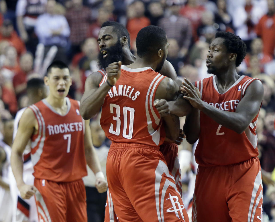 CORRECTS PERIOD TO OVERTIME - Houston Rockets guard Troy Daniel, middle, celebrates with teammates James Harden, left, and Patrick Beverley after sinking a three point shot in overtime to take the lead during Game 3 of an NBA basketball first-round playoff series against the Portland Trail Blazers in Portland, Ore., Friday, April 25, 2014. The Rockets won 121-116. (AP Photo/Don Ryan)