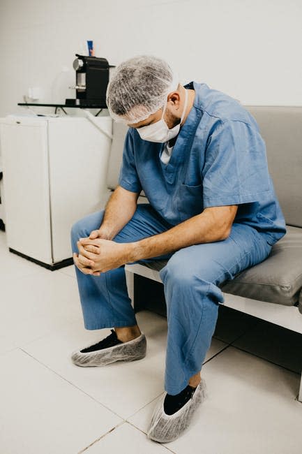 Hombre Vestido Con Traje Azul Y Máscara Sentado En Un Banco