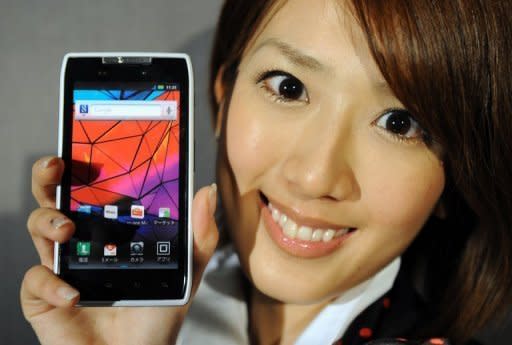 A model holds Motorola Mobility's new smartphone, Motorola Razr, at an event in Tokyo in March 2012. Google Tuesday finalized its $12.5 billion deal for Motorola Mobility, a key manufacturer of smartphones and other devices which puts the Internet giant in head-to-head competition with Apple