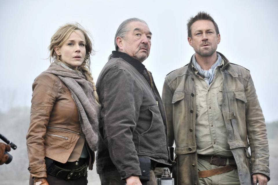 This publicity image released by Syfy shows Julie Benz as Amanda Rosewater, left, Graham Greene as Rafe McCawley, and Grant Bowler as Jeb Nolan, right, in a scene from the series, "Defiance," premiering Monday, April 15, 2013 at 9 p.m. EST on Syfy. (AP Photo/Syfy, Ben Mark Holzberg)