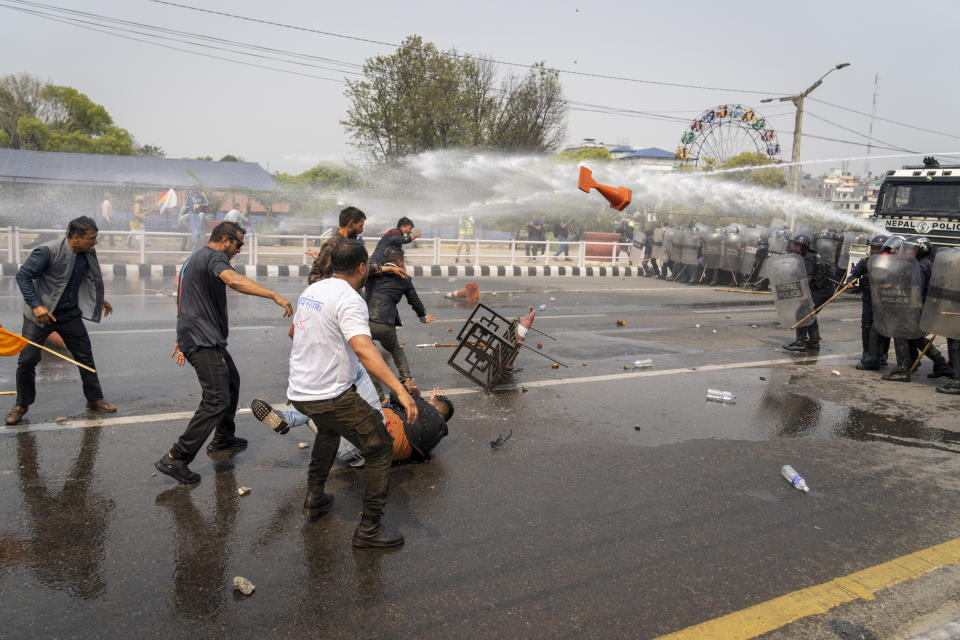 Supporters of Rastriya Prajatantra Party, or national democratic party are hit by water cannon used by policemen as they take part in a protest demanding a restoration of Nepal's monarchy in Kathmandu, Nepal, Tuesday, April 9, 2024. Riot police used batons and tear gas to halt thousands of supporters of Nepal's former king demanding the restoration of the monarchy and the nation's former status as a Hindu state. Weeks of street protests in 2006 forced then King Gyanendra to abandon his authoritarian rule and introduce democracy. (AP Photo/Niranjan Shrestha)