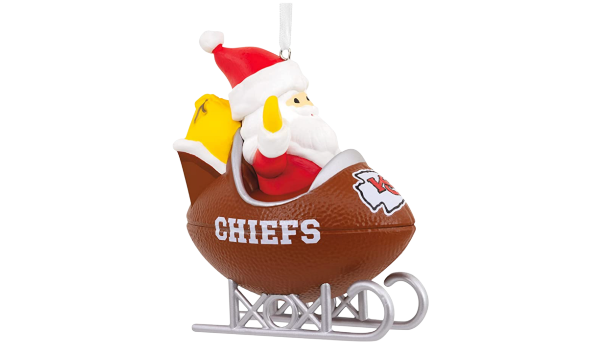 Santa in football sled with Chiefs logo in front. 